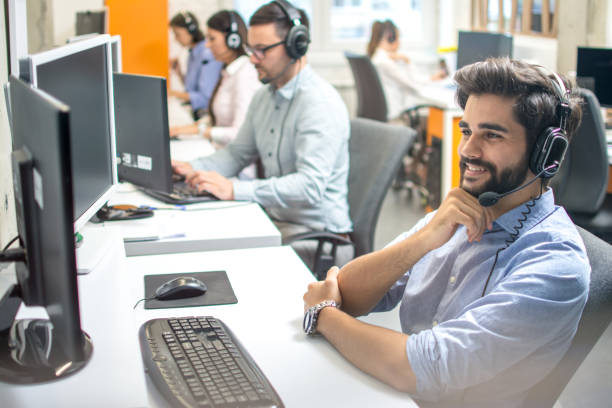 istock Dispatcher listening to a client using hands-free headset at his workplace in call center 1212984594