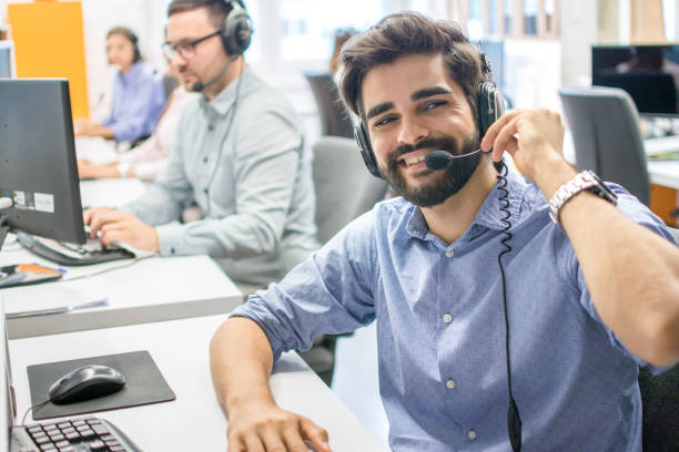 istock Close up portrait of friendly male customer support operator with headset working in call center 1212984635