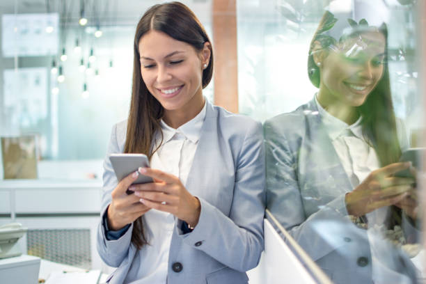 istock Young businesswoman using mobile phone in modern office. 1212984711