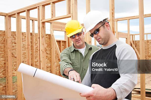 Construction Contractors Building A New Home Stock Photo - Download Image Now - Hardhat, House, Two People