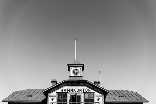 Roof of a small traditional Swedish harbour office building at midday in black and white