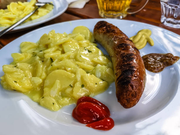 comida típica alemã com salsichas, mostarda, ketchup de tomate e salada de batata - german culture salad prepared potato bratwurst - fotografias e filmes do acervo