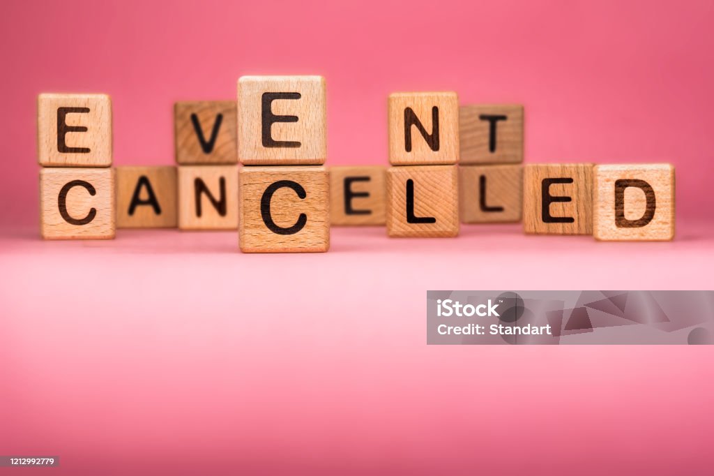 Cancel word on wooden cubes. Cancelled word made with building blocks. Mass gathering cancelled. Repatriation and quarantine of travellers. Travel advice. Protect from coronavirus infection CANCELLED word made with building blocks, business concept. Word CANCELLED on pink background. Global mass gathering cancelled. Cancelled background, Plan changing Cancellation Stock Photo