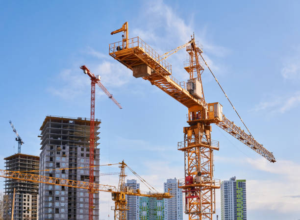 grúas torre de construcción en un sitio de construcción contra el cielo - torre fotografías e imágenes de stock