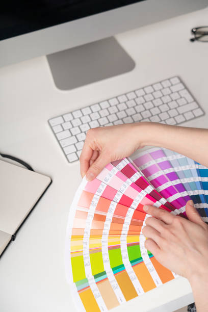 istock Graphic designer at work chooses colors for printing 1212999674