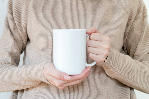 istock Mug mockup. Women's hands holding mug with blank space for your text or promotional content. 1213003882