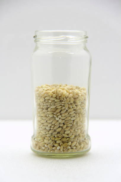 istock Glass jar with barley on a white background, side view 1213004099