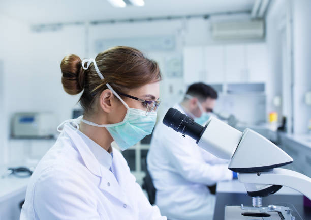 biologists working with microscope - teamwork medical research science women imagens e fotografias de stock