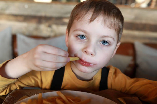 istock Child eats french fries with ketchup 1213006282