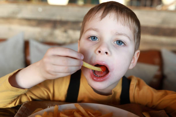 istock Boy eats french fries with ketchup 1213006296