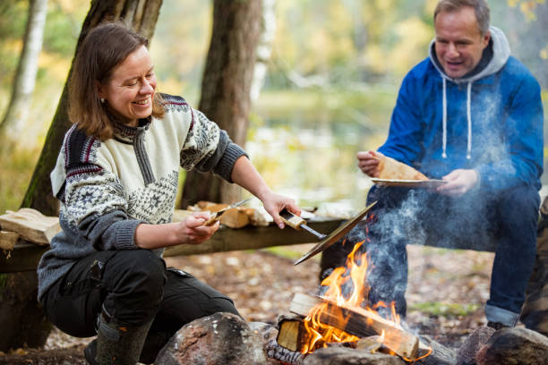 istock Man and woman making pancakes on campfire 1213007158