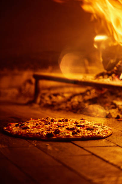 istock Delicious pizza baking in a wood fire oven 1213008400