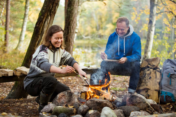 istock Man and woman making pancakes on campfire 1213008449