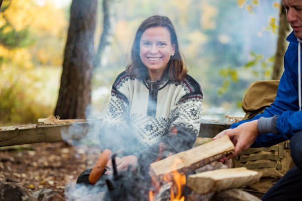 istock Man and woman roasting on campfire in forest 1213009070