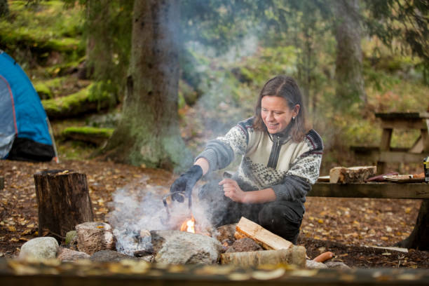 istock Man and woman making coffee in big kettle on campfire 1213009072