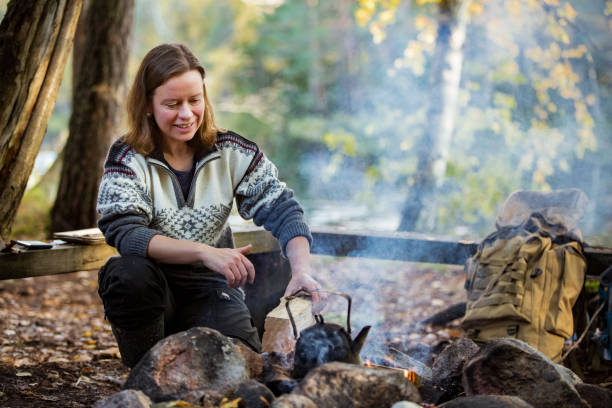 istock Man and woman making coffee in big kettle on campfire 1213010552
