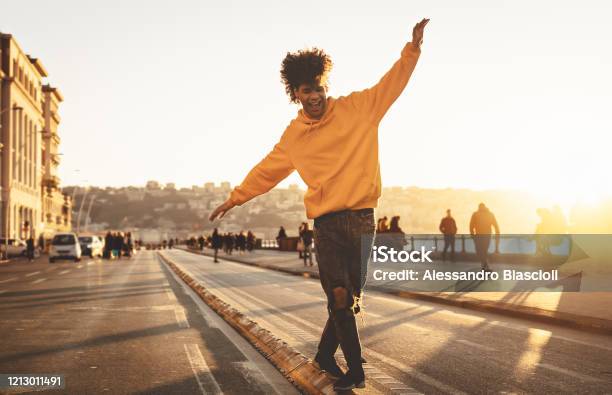 Afro American Man Having Fun Walking In City Center Happy Young Guy Enjoying Time A Sunset Outdoor Millennial Generation Lifestyle And Positive People Attitude Concept Stock Photo - Download Image Now
