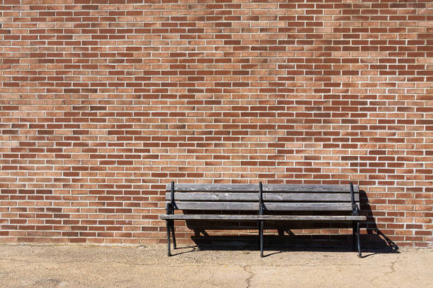 istock Wooden bench and brick wall 1213013662