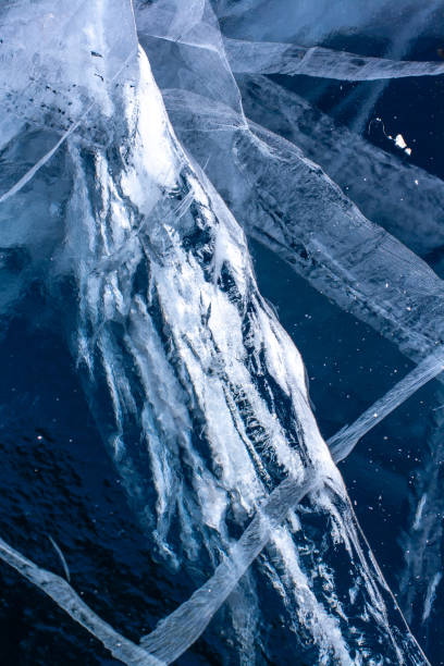 istock Natural ice texture with deep cracks. Blue transparent ice. Vertical. 1213014463