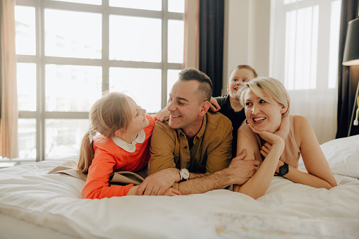 Photo of a young family in a hotel room with their children