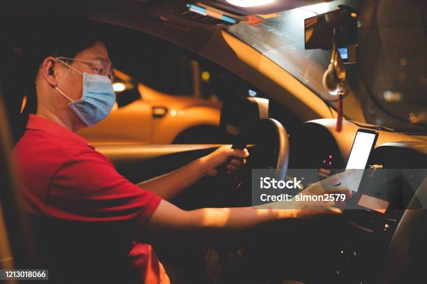 Asian Male Ehailing Driver With Face Mask Using Smartphone Stock Photo - Download Image Now