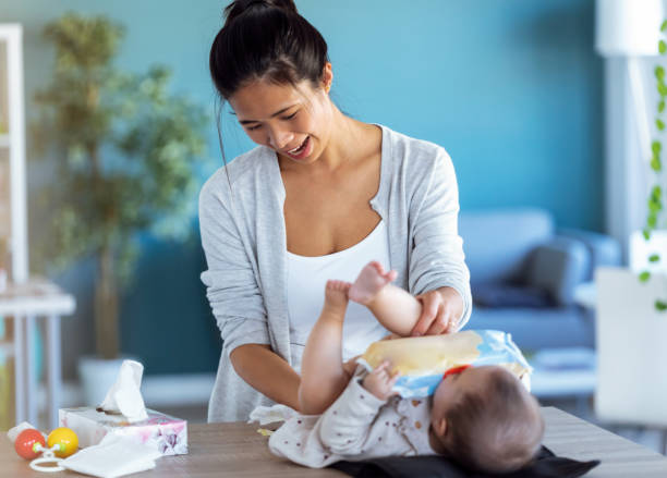 istock Smiling young mother has fun with little baby while changing his nappy at home. 1213018159