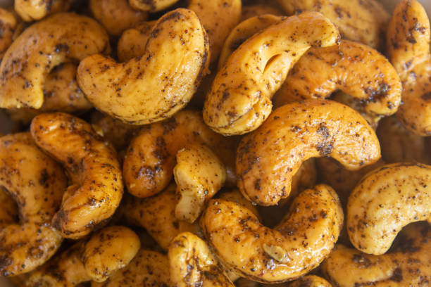 обжаренные орехи кешью с солью и смесью черного перца. - cashew close up food salted стоковые фото и изображения