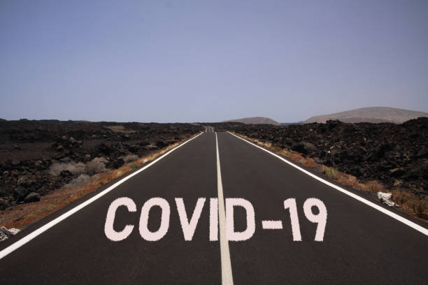 コロナウイルス不確実な暗い視点シンボルコンセプト:単語covid-19と砂漠を通る無限の道 - reference point ストック�フォトと画像