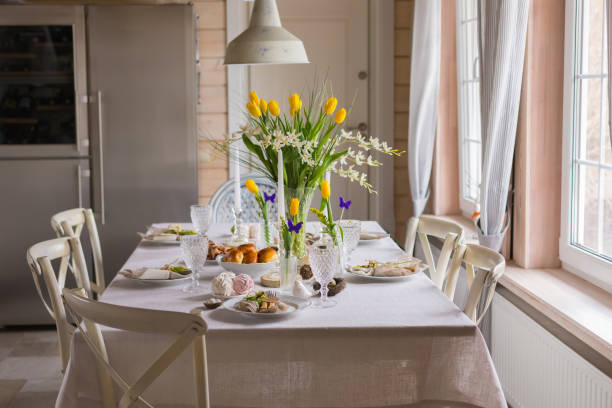 istock Easter festive spring table setting decoration, eggs in nest, fresh yellow tulips, marshmallows, selective focus 1213023521