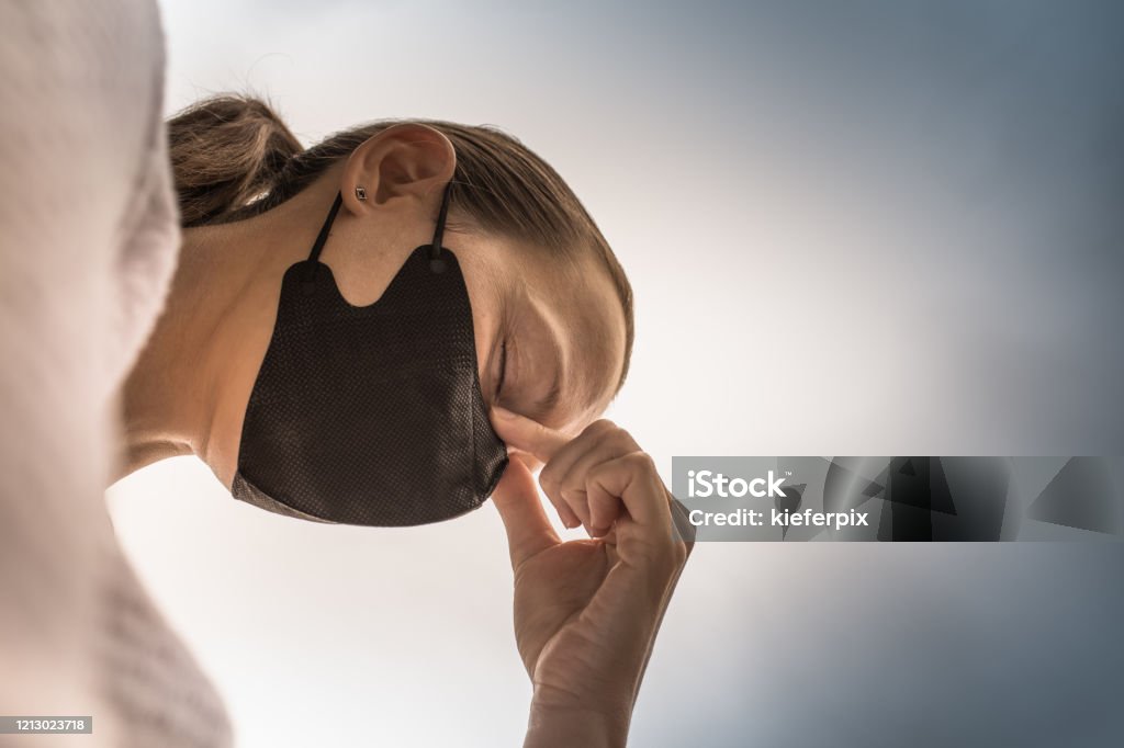 Closeup of tired stressed woman wearing face mask. Coronavirus concept. Stressed woman wearing face mask during the pandemic. Exhaustion Stock Photo