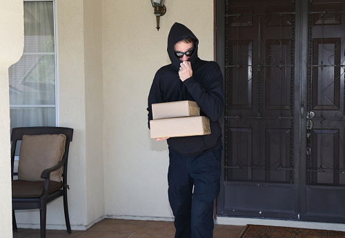 Porch pirate steals packages.  Shot in Moreno Valley, California in March of 2020.