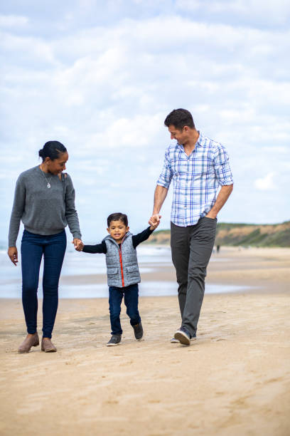 istock Young Mixed Family Walking on the Beach 1213028840