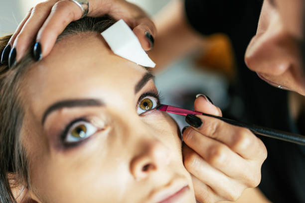 istock Professional make up treatment - MUA applying mascara and powder on the model 1213029155