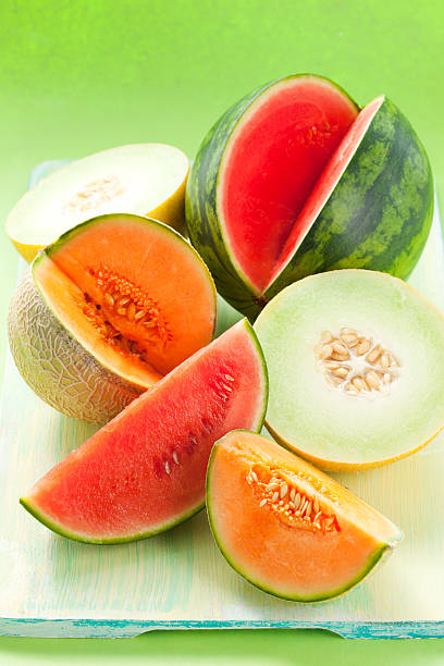 Cantaloupe, melon and watermelon on a green cutting board