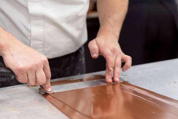 confitería profesional haciendo dulces de chocolate en la pastelería. - food industry manufacturing human hand fotografías e imágenes de stock
