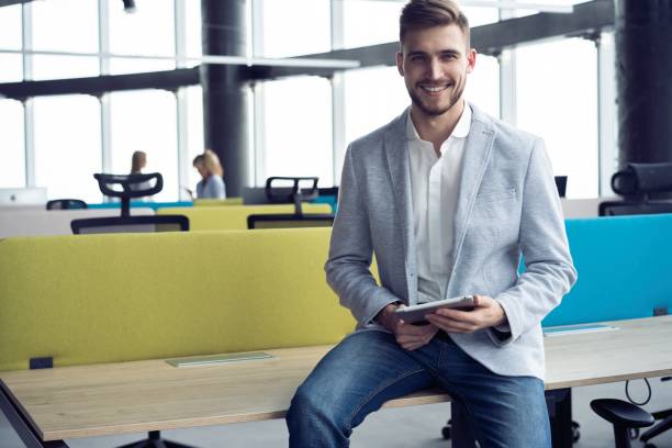 istock Happy young man smiling into the camera with a tablet in his hand. 1213033164