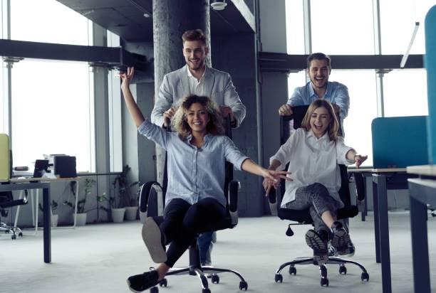 istock Positive colleagues having fun with office chairs. 1213033178