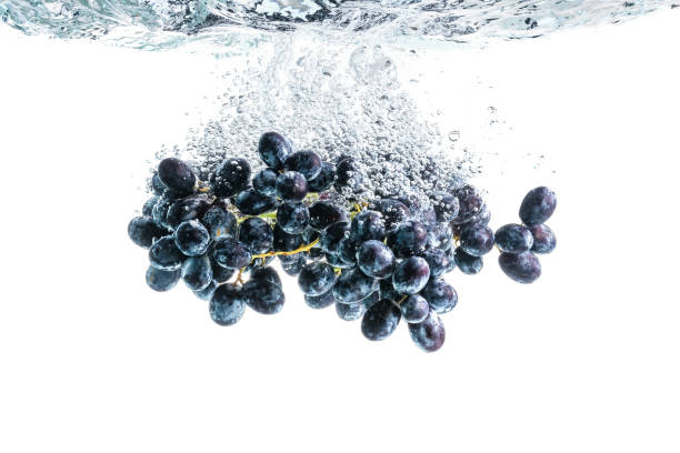 istock Bunch of red grapes splashing into crystal clear water on withe background 1213033797