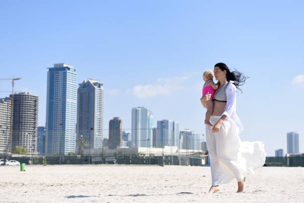 istock Mother with baby walking on the beach. 1213035606