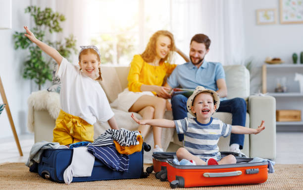 istock playful kids in suitcases with parents on sofa behind 1213039058