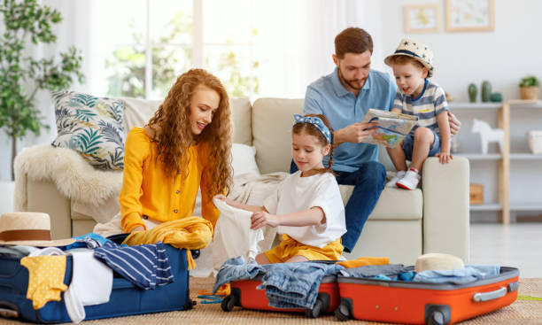 istock Family preparing for vacation while packing on floor at home 1213039169