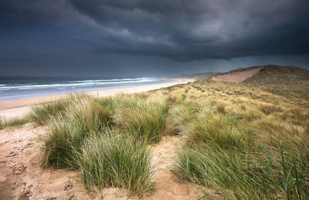 tormenta de lluvia entrante sobre dunas en la playa de bamburgh - bamburgh northumberland england beach cloud fotografías e imágenes de stock