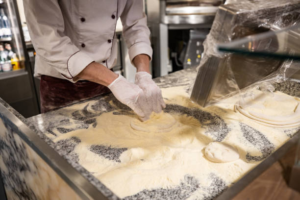 istock Man hands kneading pizza dough in an industrial environment 1213050461
