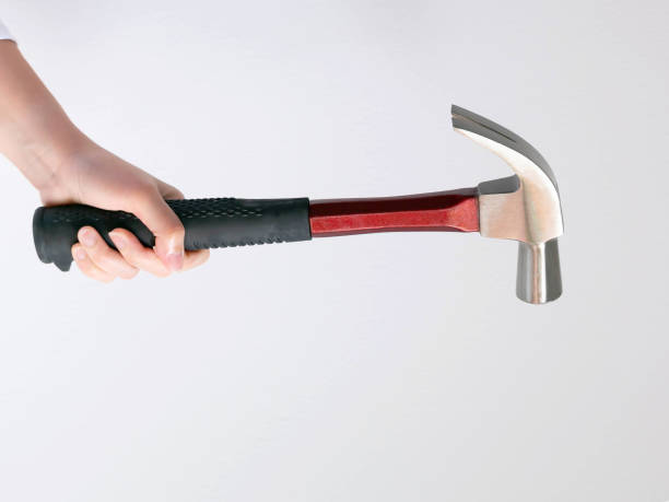 istock A hand holding a hammer on white background. 1213061764