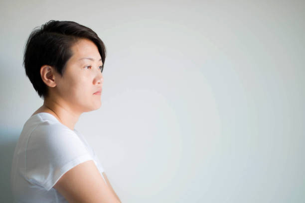 istock A sad woman introspective standing, unhappy and feeling negative on white background with copy space. 1213063668