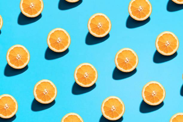 istock Orange pattern on bright light blue background. Minimal flat lay food texture. Summer abstract trendy fresh concept 1213064028