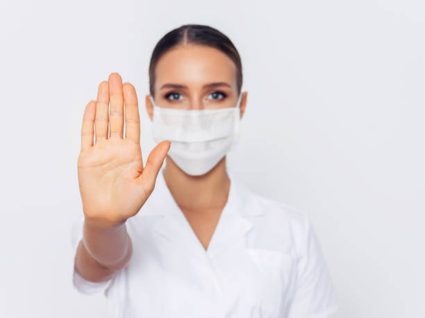 istock Doctor holding mask with stop symbol 1213064786