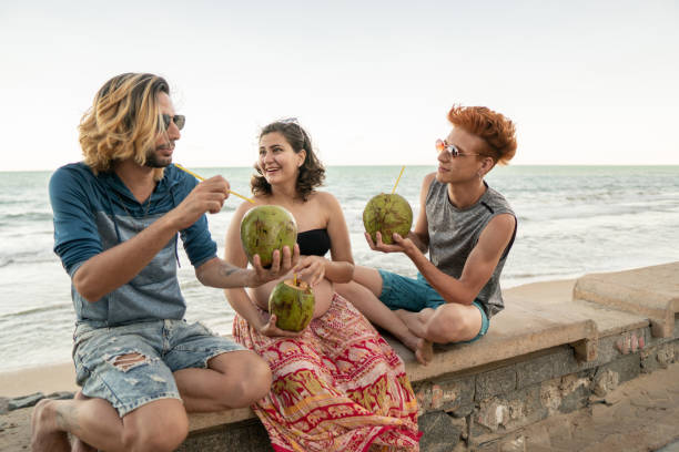 istock People on the beach drinking coconut water 1213066784