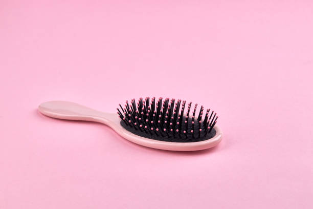 pink hairbrush isolated on a pink coral background with space. beauty hair accessory for hairstyle. stock photo