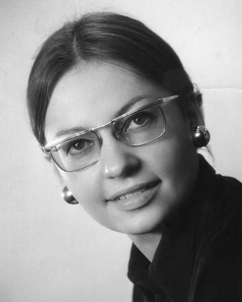 A black and white photo of a young woman in glasses stock photo